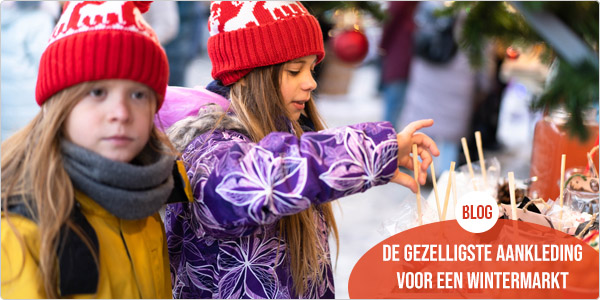 2 meisjes die op een wintermarkt rondlopen en nieuwsgierig alle versiering bekijken