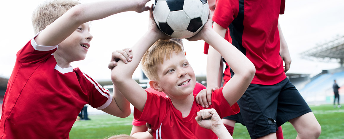 jonge voetbalspelertjes proberen de voetbal van elkaar af te nemen