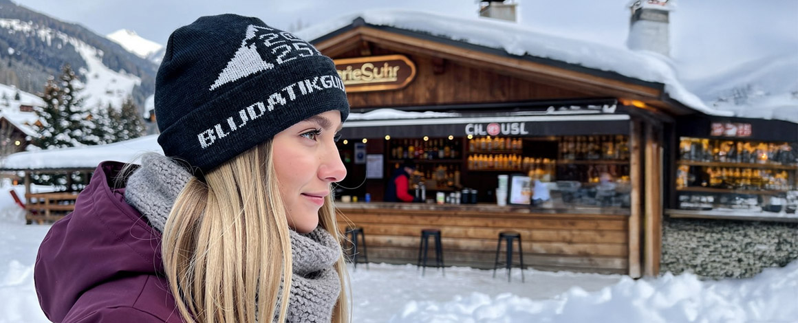 vrouw met een gebreide muts voor een apres-ski bar