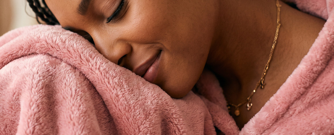 vrouw draagt een erg comfy roze badjas gemaakt met Ciclo vezels